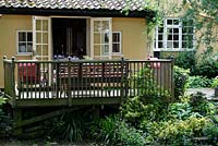 Des portes-fenêtres mènent de la cuisine à la véranda en bois et au coin salon - Sallowfield Cottage B