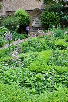 Le Musée du Jardin. Le Tudor a inspiré le parterre avec les aquilèges, les iris et les herbes et la fontaine en pierre.