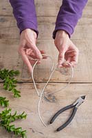 Étape par étape - Plier le fil en forme de cœur, créant une couronne de cœur à l'aide de fraises des neiges et de buxus
