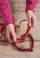 Étape par étape - ajout de ruban - Réalisation d'une décoration en forme de cœur à l'aide de canneberges