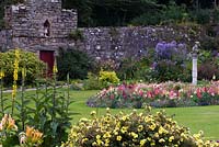 Jardin clos côtier avec parterre de l'île ronde d'Antirrhinum, Potentilla, Verbascum et ornement central