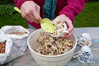 Étape par étape pour créer des mangeoires à oiseaux suspendues à partir de tasses à thé et de pots de yaourt - ajouter le mélange