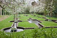 Le jardin paradisiaque avec Malus 'Evereste' fleurit au printemps - West Green House, Hampshire