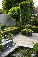 Petit jardin avec plan d'eau et terrasse en bois