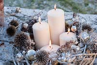 Arrangement de Noël avec couronne pulvérisée, bougies et têtes de semences collectées