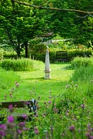 Fleurs sauvages, y compris Campion rouge, Digitalis - Foxgloves et Leucanthemum - Les marguerites Oxeye couvrent les côtés en pente du jardin, avec des chemins d'herbe tondue marqués d'obélisques en pierre et de nombreux sièges pour profiter du cadre - Le vieux presbytère