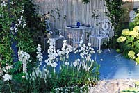 Chaises et table en métal. Campanule et lupins en parterre de fleurs blanches, Willow Pattern garden, Hampton Court Flower Show 2013, Design - Sue Thomas