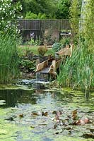 Caractéristique de l'eau moderne alimentant l'étang de jardin à travers des rigoles en bois construites - Open Gardens Day 2013, Bardwell, Suffolk