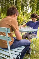 Enfants jouant aux échecs dans le jardin