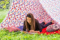 Jeune fille lisant un livre à l'intérieur d'une tente