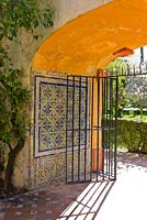 Arc d'entrée et passerelle avec décoration de carreaux Azulejos aux jardins du Real Alcazar, Séville, Andalousie, Espagne