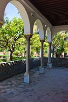 Le Pavillon de Carlos V. Murs décorés de carreaux Azulejos donnant sur le jardin de la demeure avec Séville Orangers Citrus aurantium au Real Alcázar, Séville, Andalousie, Espagne