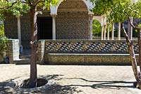 Le Pavillon de Carlos V. Murs et sièges décorés de carreaux Azulejos dans le jardin de la demeure avec des orangers de Séville Citrus aurantium à El Real Alcázar de Sevilla Andalousie, Espagne