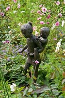 Sculpture 'Piggy Back' de Mary Cox en parterre de fleurs mixtes. Début septembre.