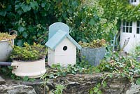 Birdbox avec pots vintage sur mur de pierre