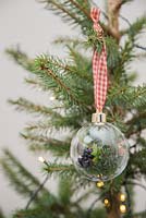 Boules naturelles sur un arbre de Noël. Fabriqué avec des boules vides, du ruban, des cônes cueillis, du feuillage et des baies