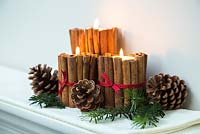 Décorations de bougies de Noël faites à l'aide de bâtons de cannelle et de ruban
