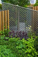 Un rideau de sphères en acier inoxydable avec des piliers en chêne dans The SeeAbility Garden