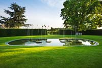 Le jardin de la loggia avec pelouse, piscine et plan d'eau
