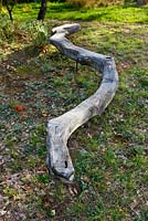Sculpture de serpent en bois parmi les arbres par Marc Nucera. Provence, France, Domaine de la Verriere