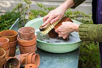 Nettoyage des pots en terre cuite dans un bol métallique d'eau bouillonnante