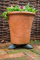 Surélever les pots du sol avec des cailloux pour aider le drainage de l'eau et empêcher l'accumulation d'humidité