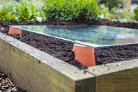 Réchauffer le sol à l'aide de pots en terre cuite et d'une feuille de verre