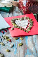 Carte de Saint Valentin décorée de graines de citrouille