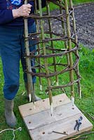 Construire un obélisque de noisetier et de saule - placer l'obélisque fini dans les trous du panneau de planche