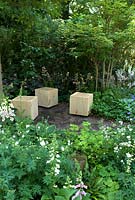 Assis dans un jardin boisé serein, entouré de plantes vivaces pour offrir la tranquillité pour profiter de la beauté de la nature - Athanasia Summer Garden, Hampton Court Flower Show 2013