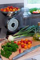 Faire de la sauce tomate avec des tomates du jardin, peser les tomates, l'oignon, le persil, l'huile d'olive, le piment, les écailles et la planche à découper