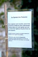 Explications, descriptions et directions affichées dans tout le jardin. Jardin des Pasradis, Cordes-sur-Ciel, Tarn, France.