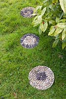 Dalles de pavage en mosaïque de galets dans l'herbe - tremplins sur la pelouse