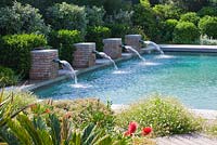 Jardin moderne et contemporain - piscine avec quatre jets d'eau en brique. Les Confines, Provence, France
