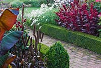 Chemin de briques avec parterres bordés de boîtes remplies d'Amaranthus 'Velvet Curtains', Pennisetum villosum, Ensete ventricosum 'Maurelii' et Pennisetum glaucum. Ulting Wick, Essex
