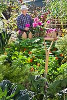 Poignée de fourche de jardin dans le potager avec jardinier derrière.