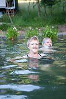 Couple nageant dans leur étang de baignade naturel - Sue et Ian Mabberley