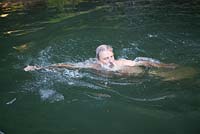 Homme nageant dans son étang de baignade naturel - Ian Mabberley