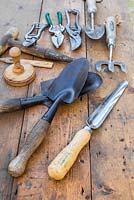 Collection d'outils de jardin vintage sur une surface en bois. Widger, truelles à main, pilper le pot, dibber de graine, fourchette et sécateur