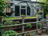 Un abri de jardin et une unité de stockage avec toit vert. Le propriétaire, Andy Hutchings, avait un panneau spécialement conçu pour la porte ci-dessus 'Andywork in Progress' parce que c'est son atelier.