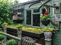 Un abri de jardin et une unité de stockage avec toit vert.