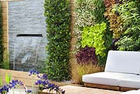 Chaises avec coussins sur terrasse en bois. RHS Hampton Court Flower Show 2014, conception: Ian Hammond