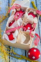 Boules à pois rouges dans un emballage en carton, avec un feuillage de mélèze