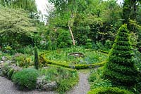 Jardin de cottage avec spirale de boîte topiaire, chemins de gravier, parterre de fleurs circulaire avec bordure de boîte naine. Parterre de fleurs surélevé avec des alpins. The Crossing House, Shepreth, Cambridge