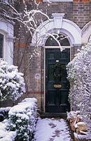 Porte d'entrée de la maison victorienne avec couronne. décembre