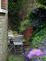 Table et chaises dans un petit jardin de la cour de la ville, caché derrière le mur de soutènement du jardin.