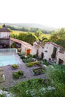 La piscine et les parterres de fraises à Grange Rousseau, Tarn, France. Contexte des collines environnantes et des ruines antiques.