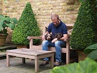Paul Morrow est assis sur la terrasse avec ses deux jeunes teckels miniatures à poil dur.