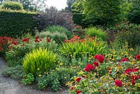 Le jardin Lanhydrock, Wollerton Old Hall. Palette de couleurs chaudes avec roses, crocosmias et alstroemerias