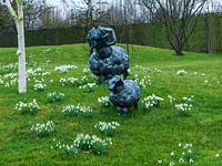 Une scène de printemps est créée avec des touffes de perce-neige naturalisés entourant des sculptures de moutons en métal.